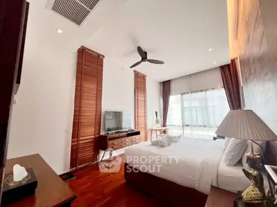 Spacious bedroom with modern decor and large windows for natural light.
