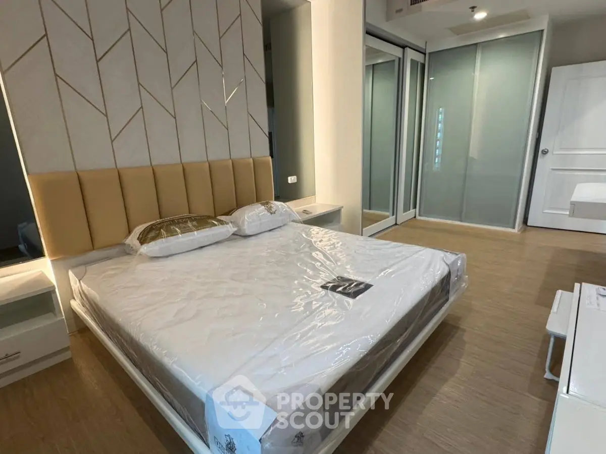 Modern bedroom with stylish headboard and sleek wooden flooring