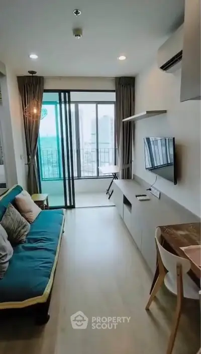 Modern living room with balcony view, featuring sleek furniture and natural light.