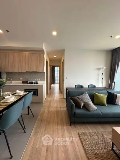 Modern open-plan living room with stylish kitchen and cozy seating area, perfect for urban living.
