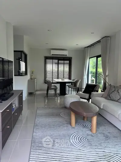 Modern living room with stylish furniture and large windows offering natural light.