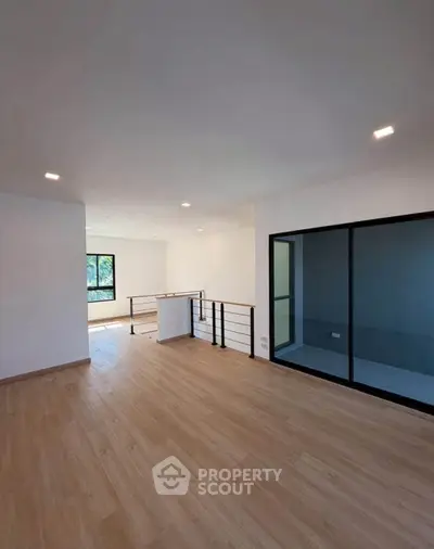 Spacious modern living room with wooden flooring and large windows