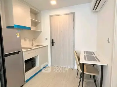 Modern compact kitchen with sleek design and dining area in a stylish apartment.