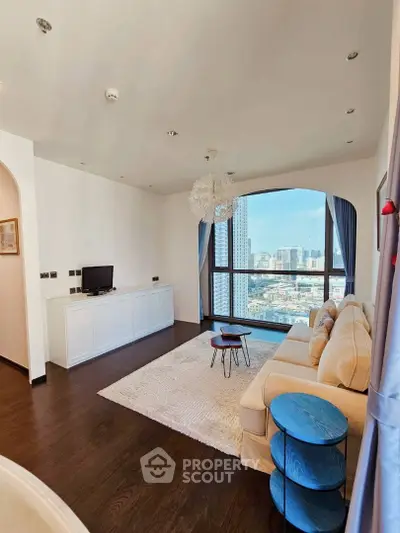 Spacious living room with hardwood floors, large windows offering city views, and modern furnishings, ideal for upscale urban living.