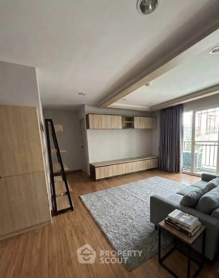 Spacious modern living room with wooden flooring and large window for natural light.