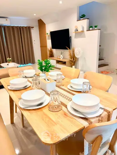 Modern dining area with stylish wooden table set in open-concept living space, perfect for entertaining.