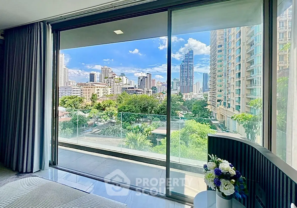 Luxurious high-rise apartment with stunning city view from spacious balcony.
