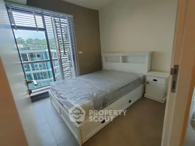 Modern bedroom with large window and natural light in a contemporary apartment.