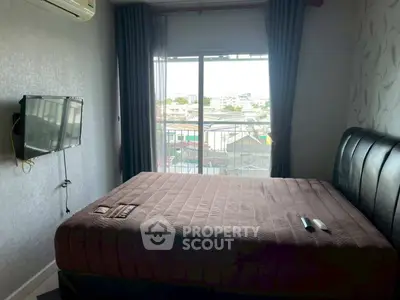 Cozy bedroom with city view, featuring a wall-mounted TV and air conditioning for comfort.