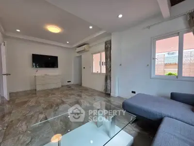 Spacious modern living room with sleek tile flooring and stylish furniture, perfect for relaxation and entertainment.