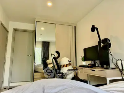 Modern bedroom with sleek desk setup and mirrored wardrobe