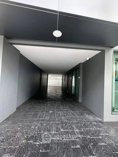 Modern building entrance with sleek design and dark tiled flooring