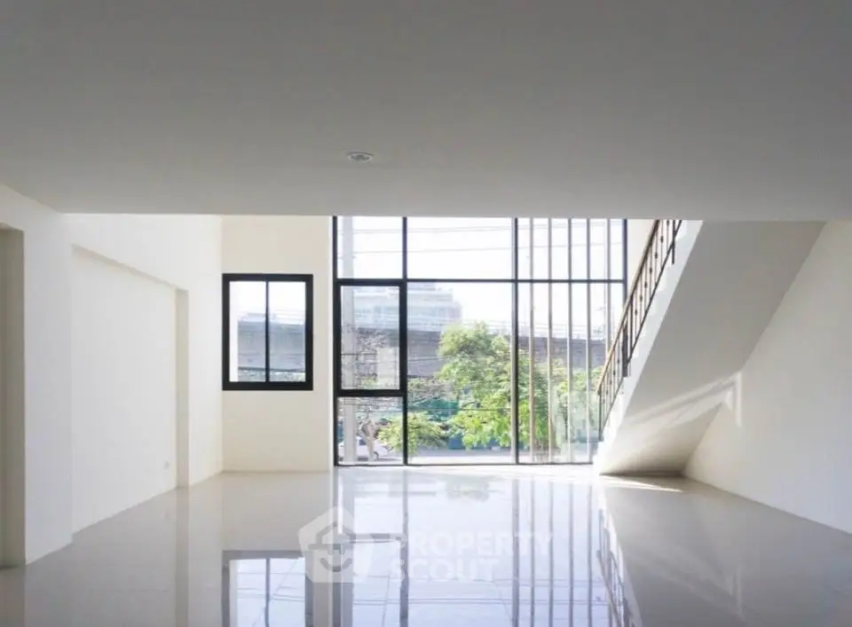 Spacious modern living room with large windows and glossy floors