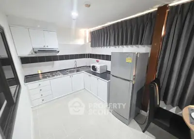 Modern kitchen with sleek white cabinets and stainless steel appliances