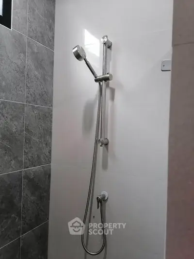 Modern bathroom shower with sleek chrome fixtures and tiled walls.