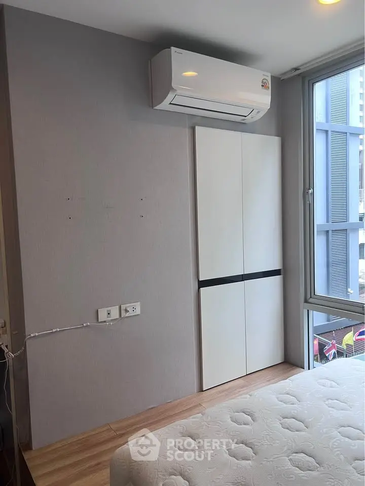 Modern bedroom with air conditioning and large window in urban apartment
