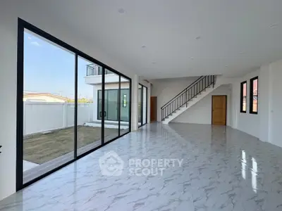 Spacious modern living room with large windows and marble flooring
