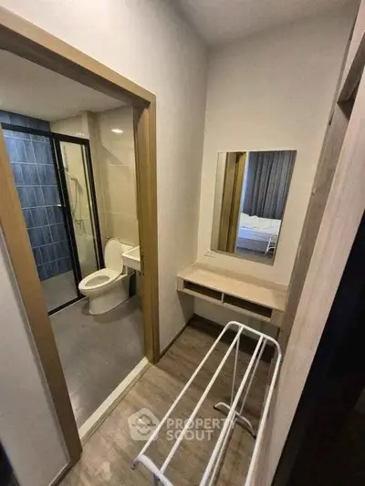 Modern bathroom with sleek design and adjacent vanity area