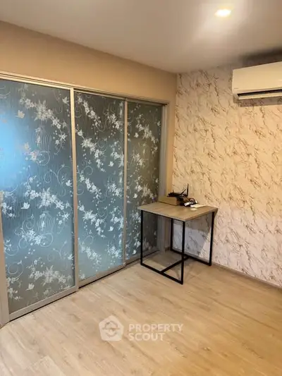 Modern room with stylish sliding glass doors and air conditioning, perfect for a cozy home office or study area.