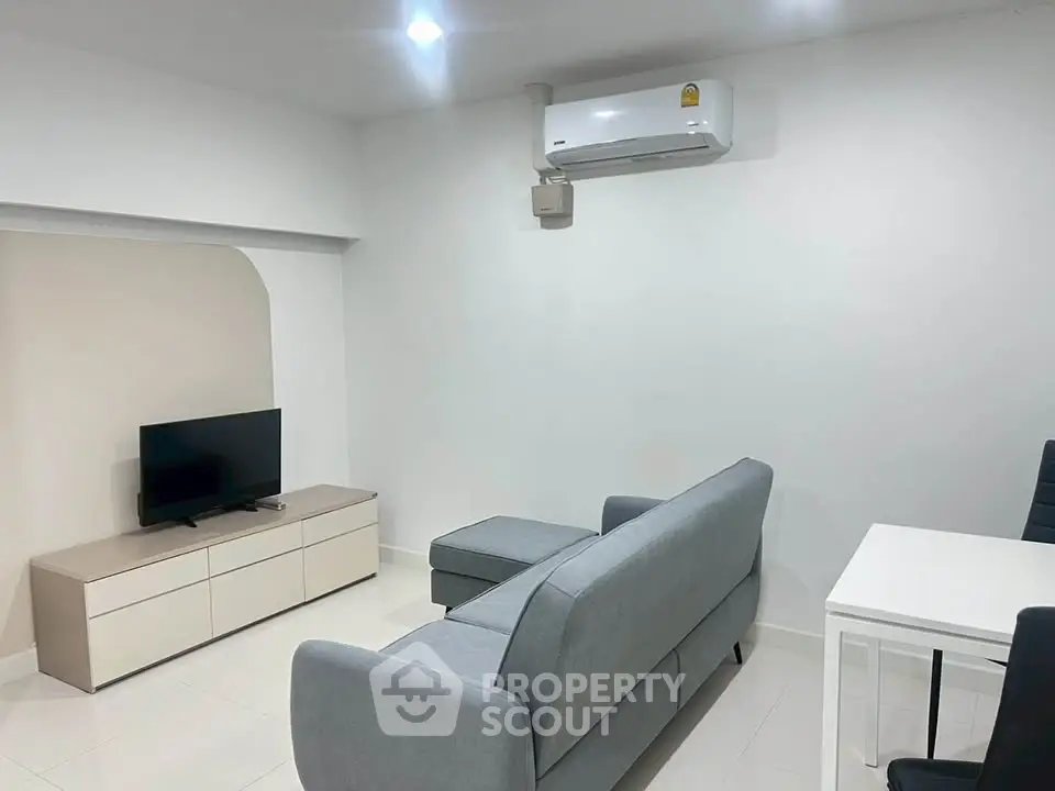 Modern living room with sleek furniture and air conditioning, ideal for comfortable living.