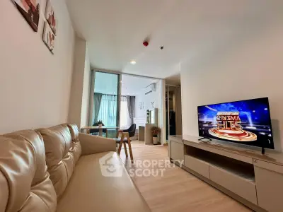 Modern living room with sleek furniture and a large TV, perfect for relaxation and entertainment.