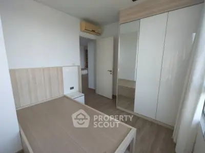 Modern minimalist bedroom with wooden furniture and mirrored wardrobe