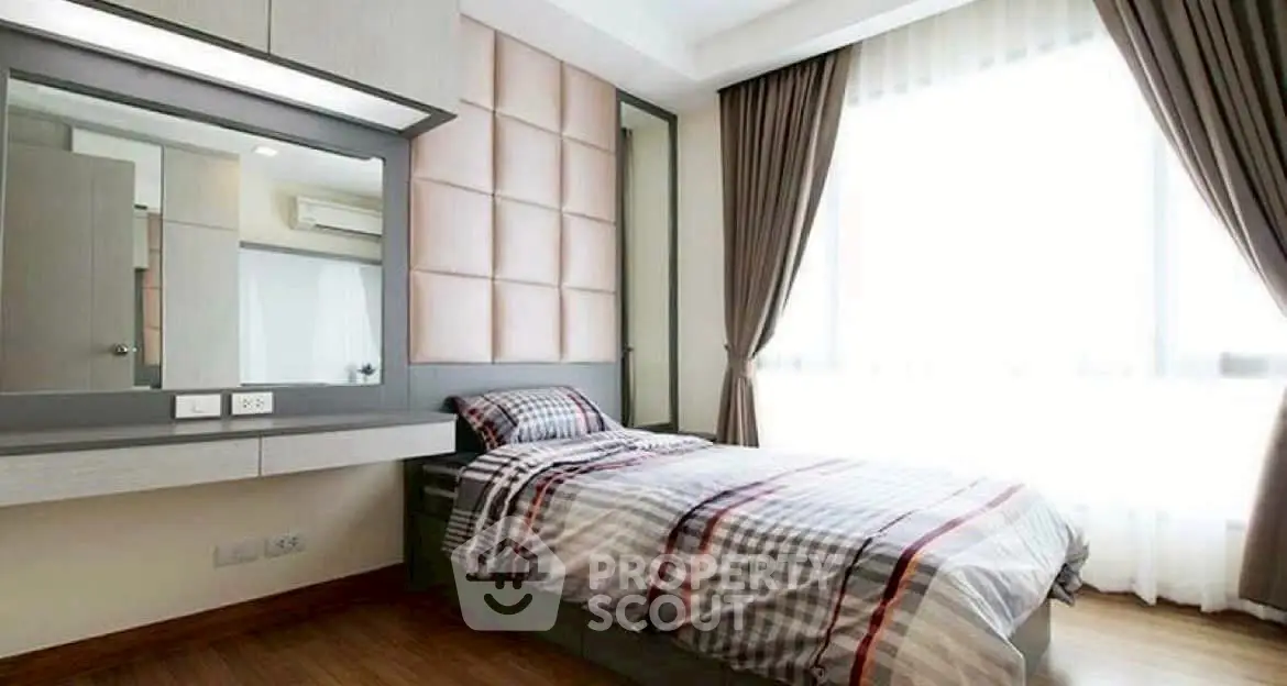 Modern bedroom with stylish decor and large window for natural light.