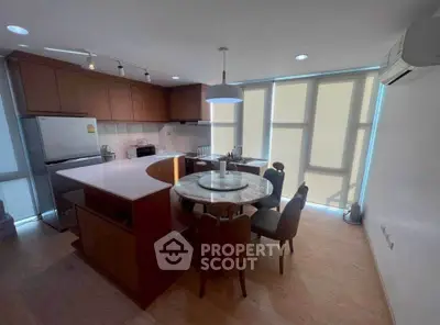 Modern kitchen with round dining table and sleek wooden cabinetry