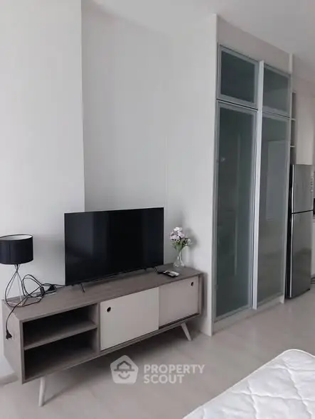 Modern living room with sleek TV stand and glass-paneled storage, perfect for contemporary living.