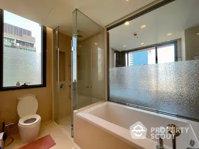 Luxurious modern bathroom with glass shower and large bathtub in high-rise apartment