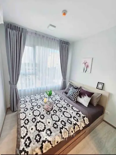 Cozy bedroom with stylish decor and large window for natural light