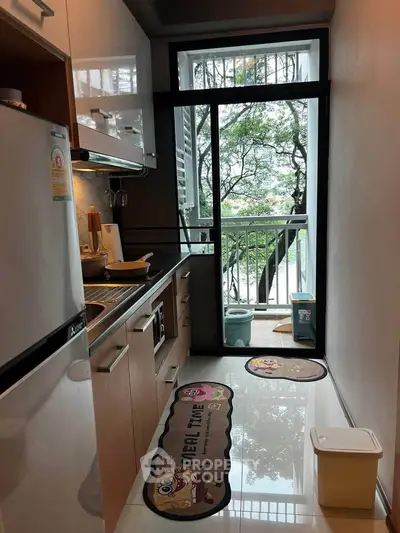 Modern kitchen with sleek cabinets and balcony view, featuring open layout and natural light.