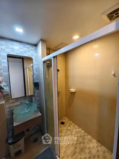 Modern bathroom with glass sink and spacious shower area