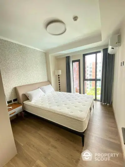 Modern bedroom with large window and stylish decor in a high-rise apartment.