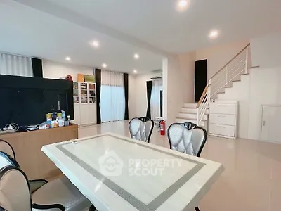 Spacious modern living area with elegant dining setup and staircase