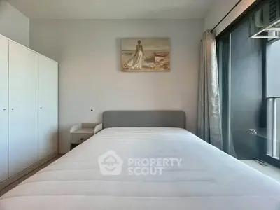 Spacious bedroom with large window and modern decor, perfect for natural light lovers.