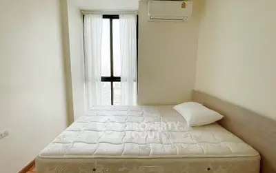 Bright bedroom with large window and air conditioning unit, perfect for comfort and relaxation.