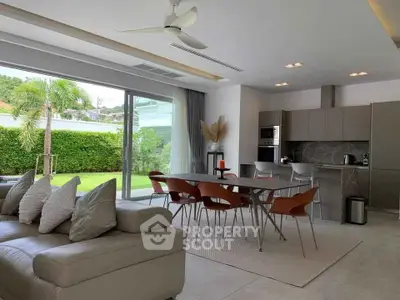 Modern open-plan living room with sleek kitchen and garden view, perfect for entertaining.