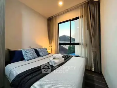Cozy bedroom with large window and elegant curtains, perfect for relaxation and comfort.