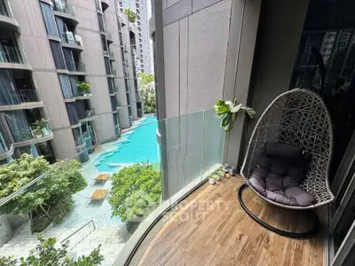 Luxurious balcony with hanging chair overlooking modern pool and lush greenery in urban setting.