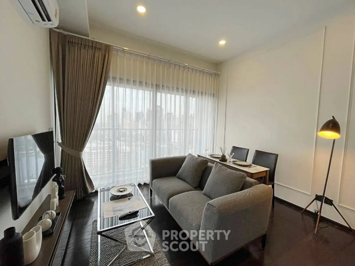 Modern living room with city view, featuring sleek furniture and elegant decor.