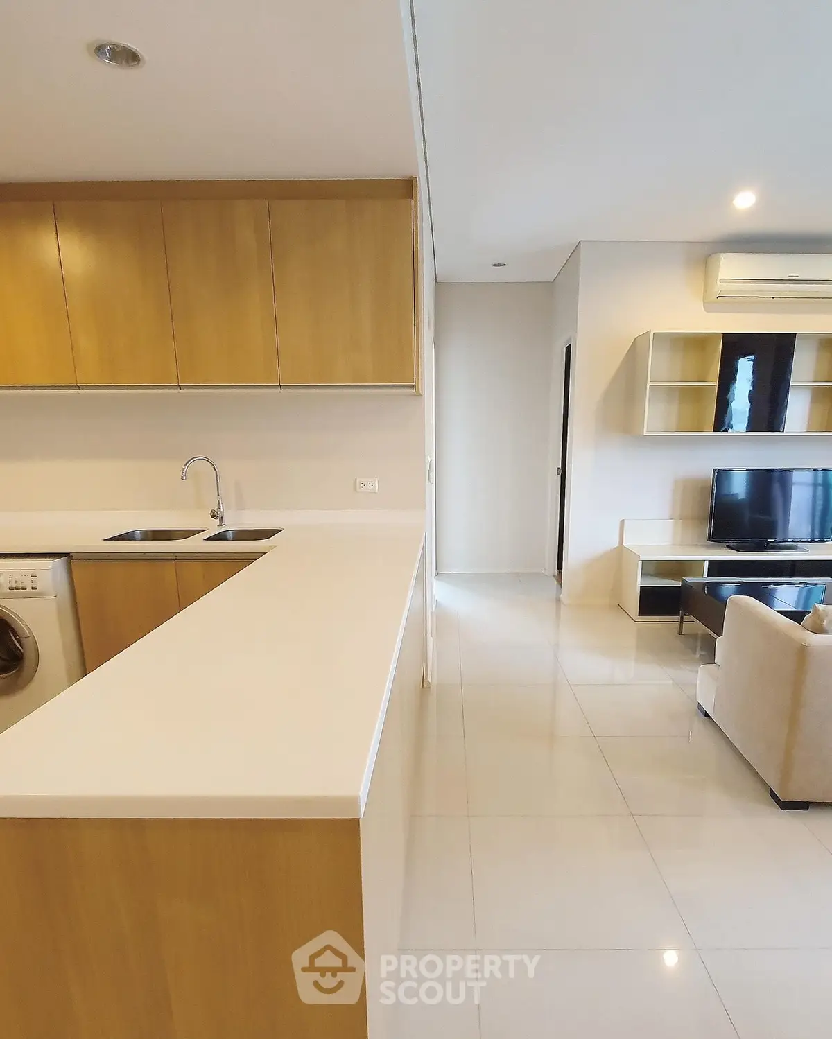 Modern open-plan kitchen and living room with sleek design and neutral tones.