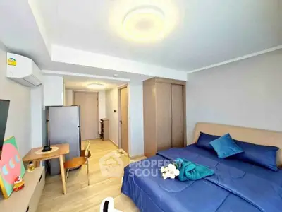 Modern bedroom with stylish decor and ample natural light, featuring a cozy bed and sleek furniture.