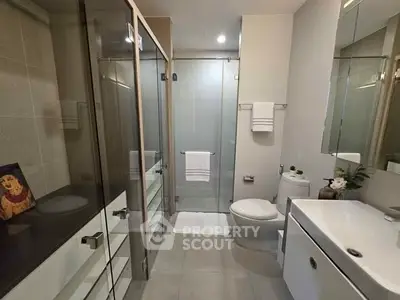 Modern bathroom with glass shower and sleek fixtures in a contemporary apartment.