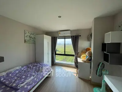 Bright bedroom with large window and scenic view, featuring modern furniture and cozy decor.