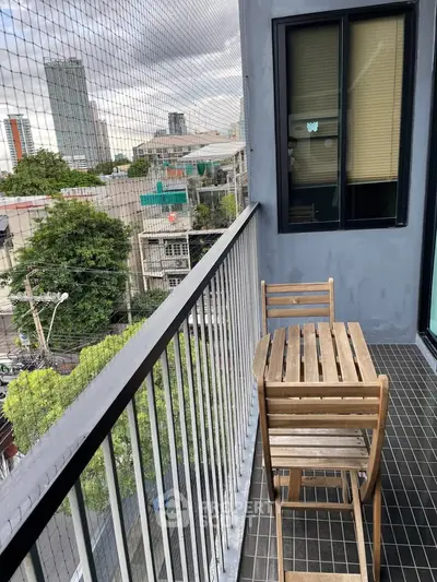 Charming urban balcony with city view, perfect for relaxation and outdoor dining.