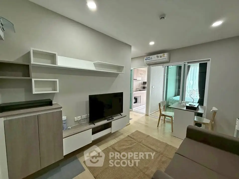 Modern living room with sleek furniture and open kitchen layout in a stylish apartment.