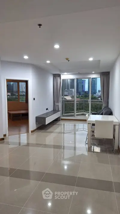 Spacious modern living room with city view and sleek tile flooring