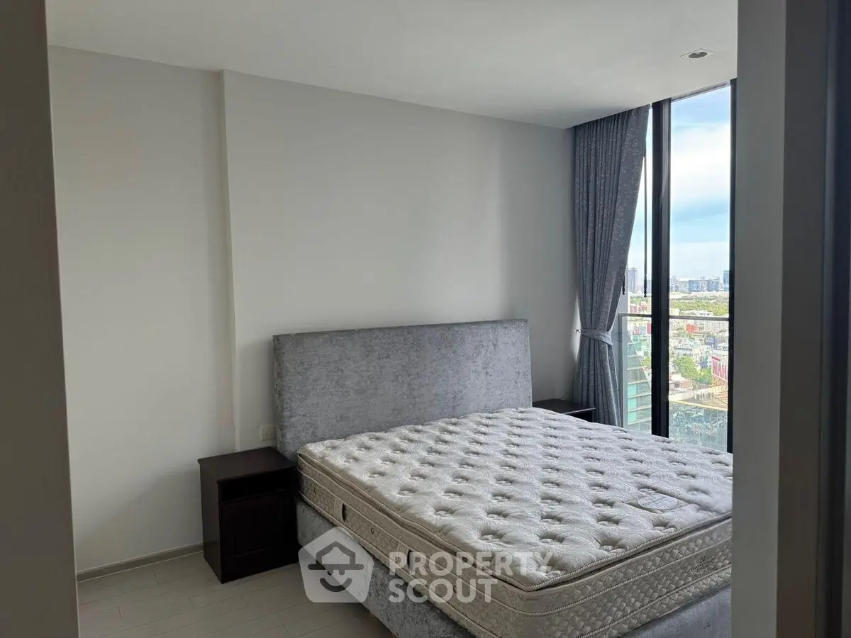 Modern bedroom with large window offering stunning city view