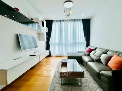 Modern living room with sleek furniture and large window, perfect for urban living.
